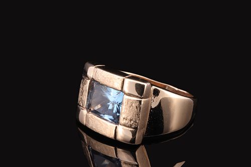 A gold ring with a square-cut aquamarine gemstone.