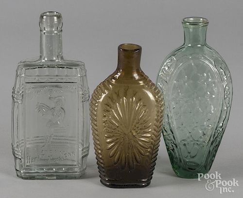 Two blown glass flasks, 19th c., together with a later Merry Christmas Happy New Year bottle, talles