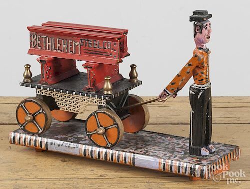 Contemporary carved and painted folk art figure pulling a cart of beams, inscribed Bethlehem Steel