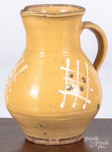 Redware pitcher, 19th c., with cream glaze and white slip decoration, 9 3/4'' h.
