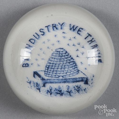 Dark blue enameled paperweight on a white ground with beehive, inscribed By Industry We Thrive, 3