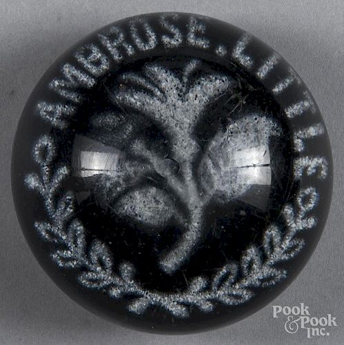 White frit paperweight, inscribed Ambrose Little around a central flower, on a dark blue ground, 3