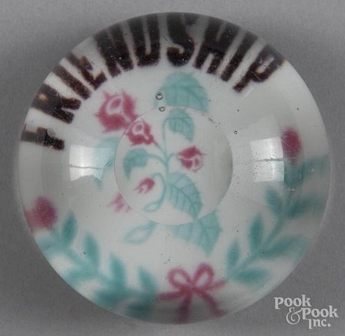 Colored frit Friendship paperweight, with a floral sprig over an opaque white ground, with top fac