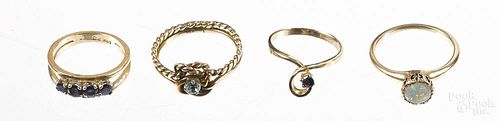 Four 14K yellow gold rings, to include examples set with sapphires, an opal, and a light blue stone,