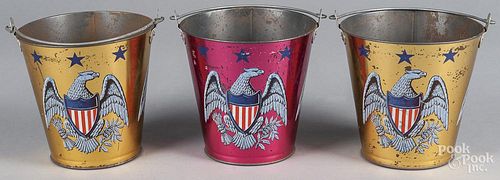 Three Ohio Art tin lithograph sand pails, 20th c., with American eagle with shield chest, 6'' h.