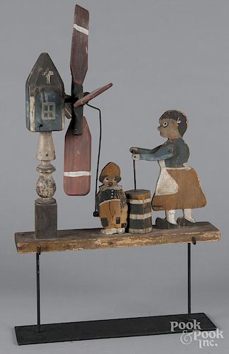 Painted whirligig, early 20th c., of a woman churning butter, 20'' h., 18'' w.