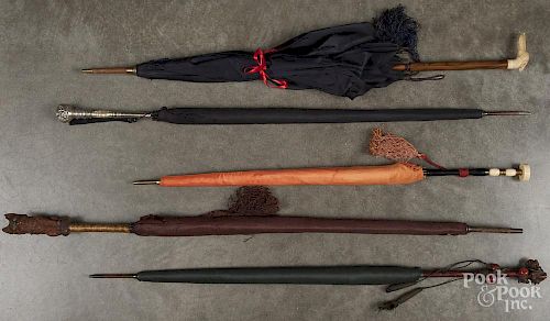 Five assorted parasols, to include a carved cat grip, silver grip, etc.