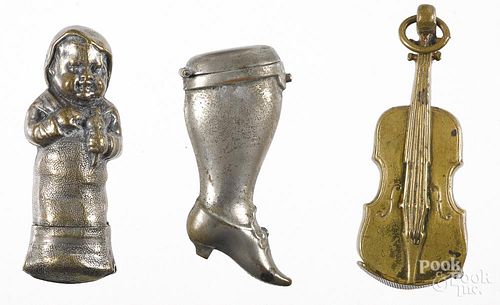 Three figural match vesta safes, to include a brass violin, nickel plated baby with rattle, and a ni