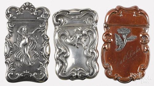 Three match vesta safes, to include one with a bronze finish with a sterling flower overlay, 2 5/8''
