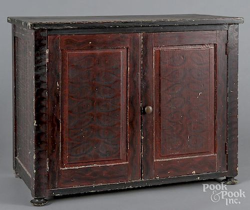 Painted pine low cupboard, 20th c., retaining a red and black grained surface, 22 1/2'' h., 29'' w., 1