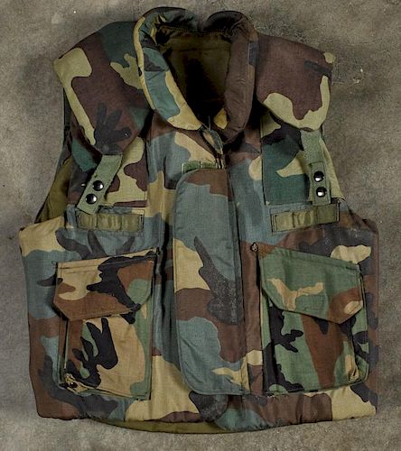 Three camouflage military flak jackets, dated 1981, two green and one tan.