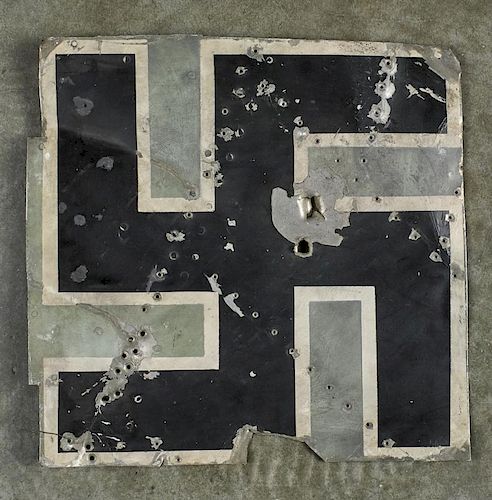 WW II Nazi aluminum swastika, cut from a German airplane, with bullet holes and pencil inscription