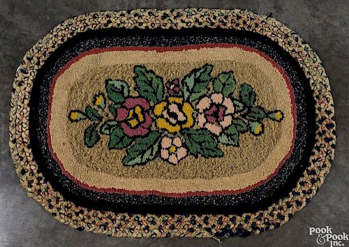 Hooked floral rug with a braided border, 3'4'' x 2'4''.