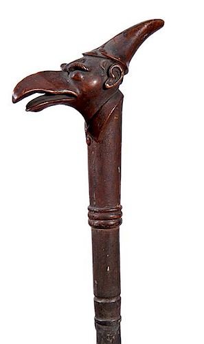 300. Creature Folk-Art Cane – Ca. 1880 – A one-piece carved hardwood cane with what appears to be a creature with human e
