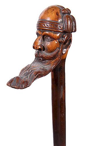 316. Folk-Art Man Cane – Ca. 1900 – A detailed carving of a man in a large mustache and long beard in a fez with a pair o