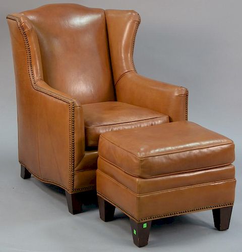 Henredon tan leather upholstered wing chair with footstool.