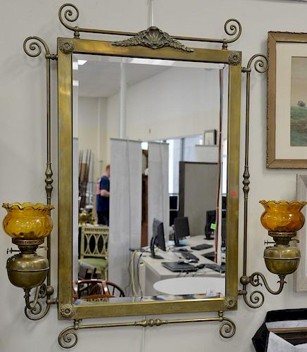 Large Victorian brass framed mirror having mounted oil lamp sconces with glass shades. ht. 49in., wd. 37in. plus adjustable a