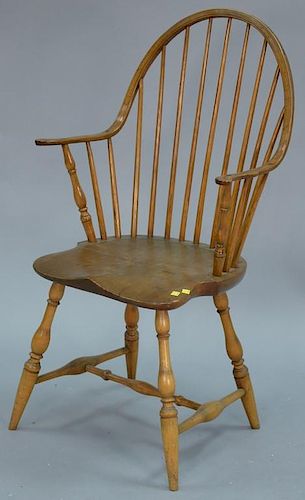 Antique continuous armchair with turned legs and stretcher base.