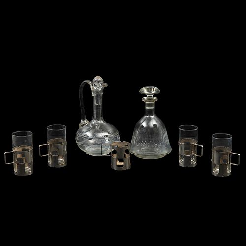 LOTE DE ARTÍCULOS DE MESA, SEGLO XX. Elaborados en cristal y vidrio transparente y metal plateado. Consta de jarra, licorera y 4 vasos.
