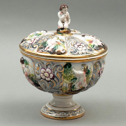 BOMBONERA, ITALIA, SIGLO XX. Elaborada en porcelana policromada, sellada Capodimonte. Decoración floral y querubines en relieve.