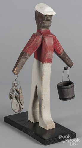 Carved and painted black Americana figure holding a bucket and fish, second half 20th c., 16'' h.