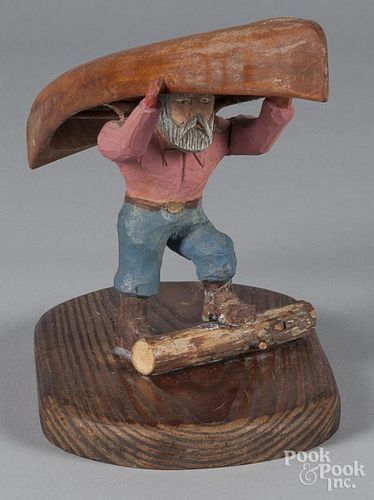 Carved and painted pine figure of a bearded man portaging a canoe, 7 3/4'' h.