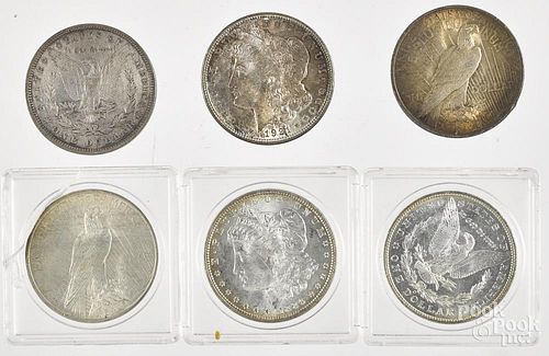 Four Morgan silver dollars, with two Peace dollars, to include an 1886 and a 1904.