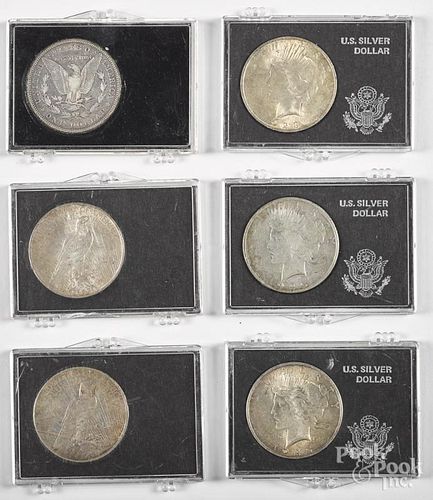 Two Morgan silver dollars, 1889 and 1884, together with seven Peace dollars.