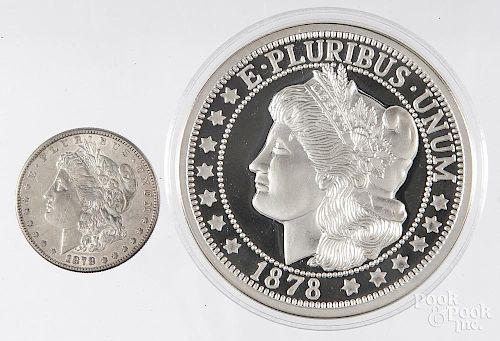 Half pound .999 silver round, together with an 1878 S Morgan silver dollar.