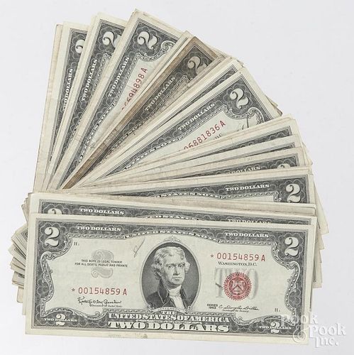 Fifty-seven two dollar US notes with red seals, together with a twenty dollar Federal Reserve note.