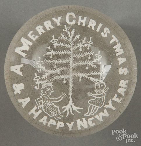 White frit Merry Christmas & A Happy New Year paperweight, with a Christmas tree and two children,