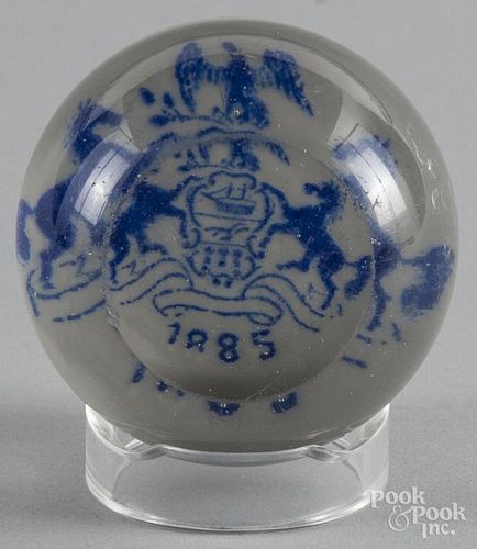 Blue frit paperweight, with a coat of arms over a white ground, dated 1885 with a top facet, 3'' di