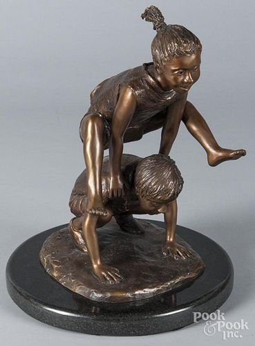 Bronze of a boy and girl playing leap frog, signed