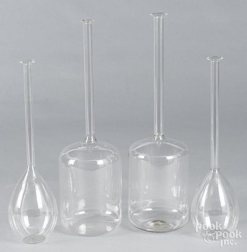 Four colorless glass thin neck bottles