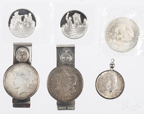 Two silver dollars set in money clips, to include a Morgan dollar, 1921, and a Peace dollar, 1923, f