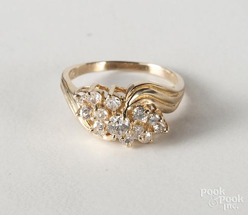 14k yellow gold and diamond ring, with a cluster of twelve diamonds flanking an approx. .15 carat di
