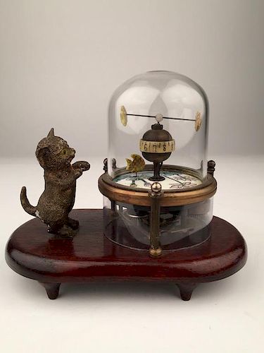 A novelty clock with a kitten looking at a fish tank.