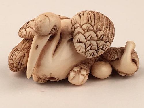 A carved Netsuke figure of a large swan and two younger swans.