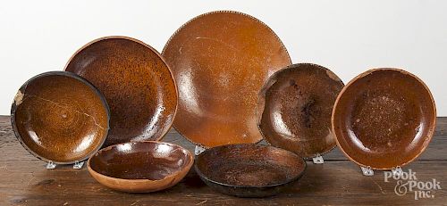 Twelve assorted redware plates and shallow bowls, 6 3/4'' - 11 1/2'' dia.