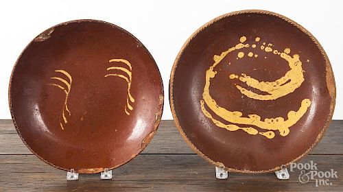 Two redware deep dishes, 19th c., with yellow slip decoration, 11 1/2'' dia. and 10 1/2'' dia.