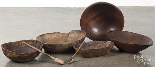 Five wooden bowls, together with two serving spoons and an iron trivet.