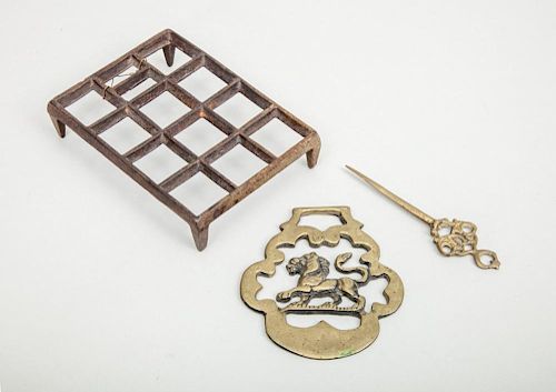 ENGLISH "LION PASSANT" HORSE BRASS, A GILT-METAL PIN AND A WROUGHT-IRON GRID