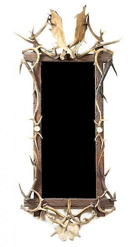 A Rustic Carved Wood and Caribou Antler Mirror Height 71 x width 34 inches.