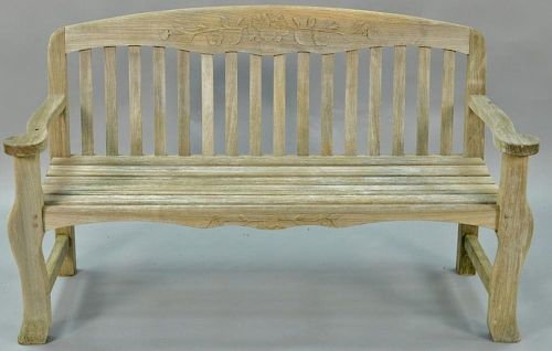 Teak bench with arms and flower carved back, signed Kingsley-Bate. wd. 57in.