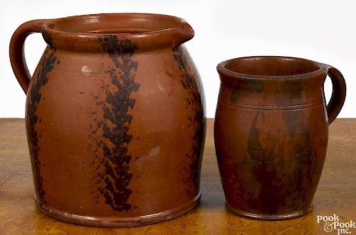 Two Pennsylvania redware pitchers, 19th c., 7 1/4'' h. and 5 3/4'' h.