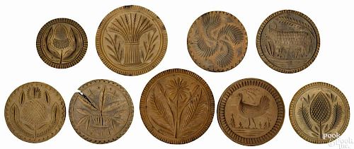 Collection of nine carved wooden butter prints, 19th c., to include a rooster, a cow, an acorn, a