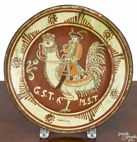 Continental redware charger, 19th c., with slip decoration of a gentleman riding a rooster, initia