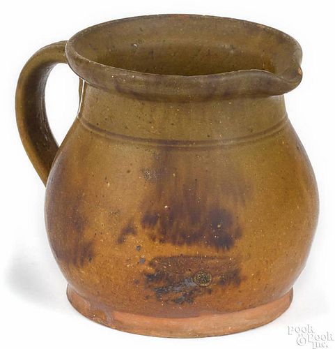 Pennsylvania redware pitcher, 19th c., with mottled green, orange, and brown glaze, 4 1/4'' h.