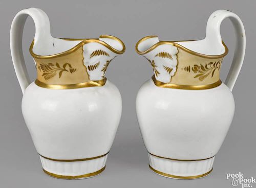 Pair of Philadelphia Tucker porcelain pitchers, ca. 1825, with gilt decoration and a tan band unde