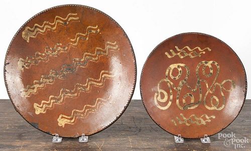 Two redware plates, 19th c., with yellow slip decoration, 9'' dia., 11 1/4'' dia.